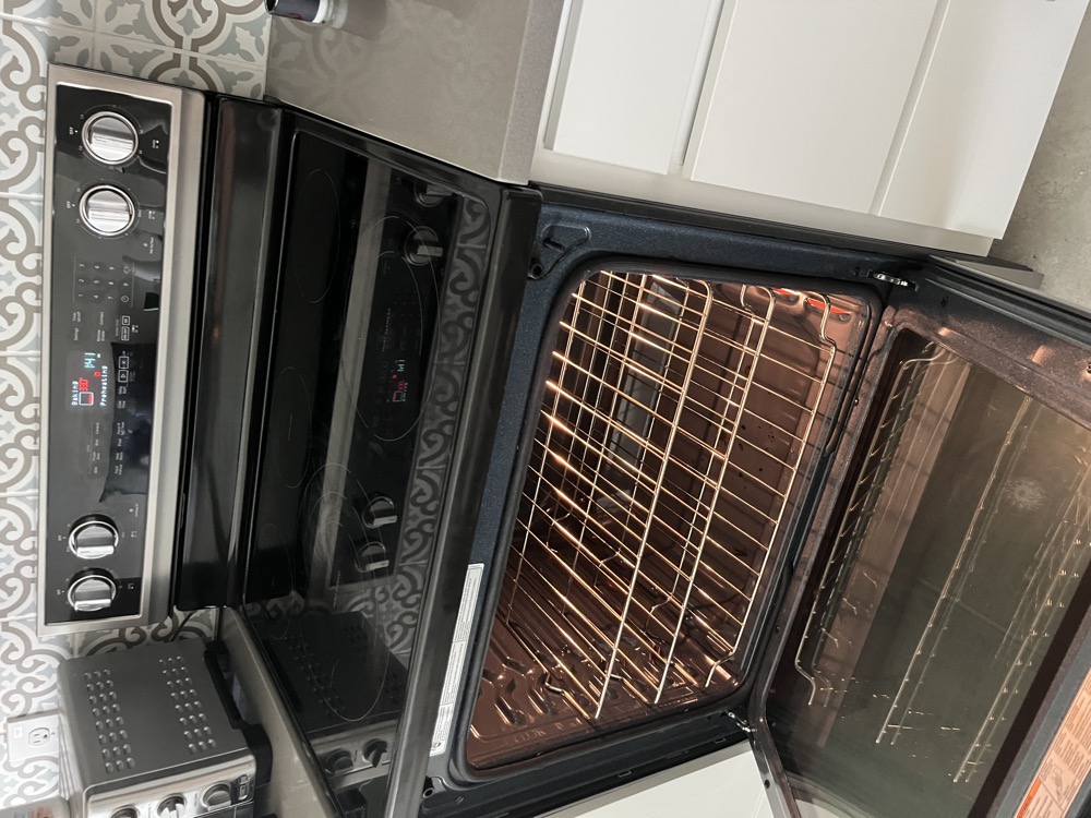 Electric range with the oven door open, bake element visible at the bottom