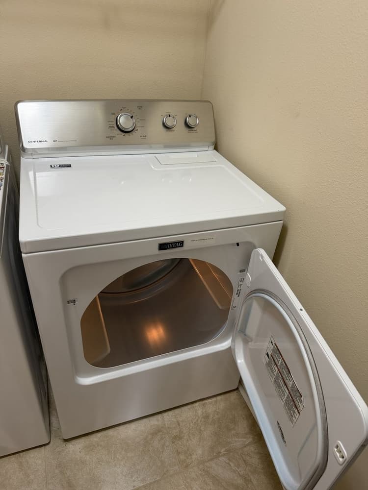 Maytag Centennial dryer back in service after a dryer vent clean-out, with the dated service sticker on the door