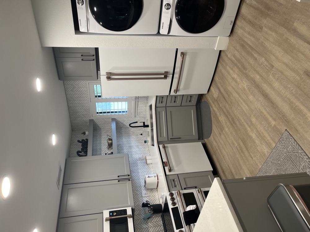 Tampa Bay kitchen with a built-in dishwasher under the counter beside the sink and a stacked washer and dryer column at the far end