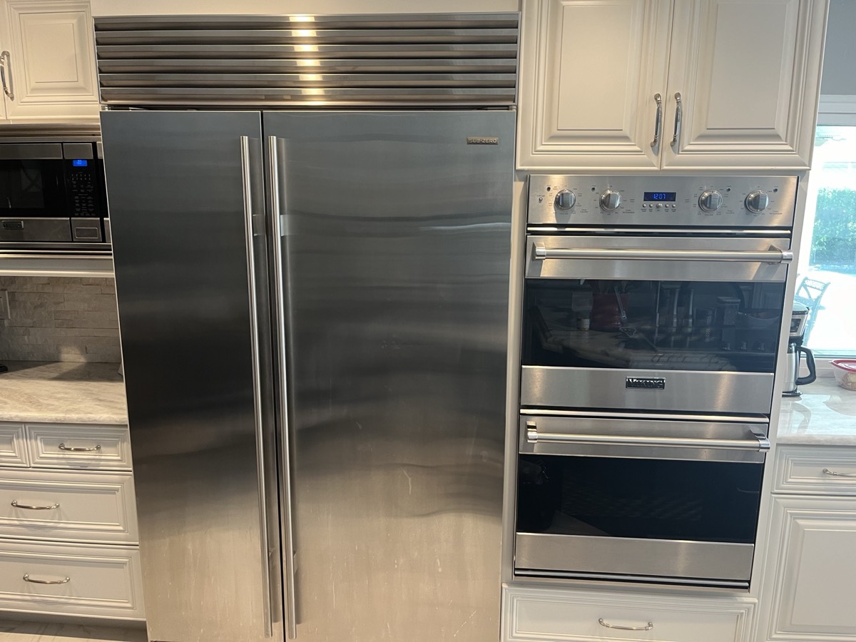Sub-Zero built-in refrigerator beside a premium wall oven in a Tampa Bay kitchen