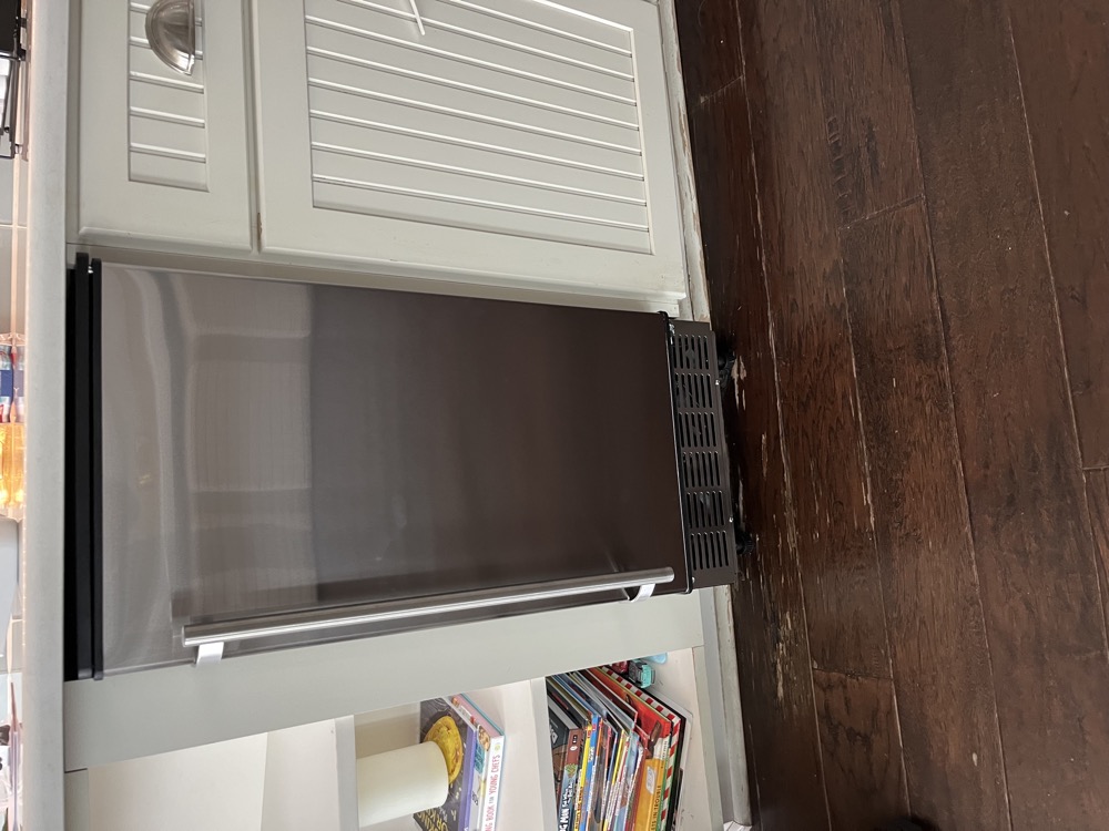 Narrow stainless refrigerator serviced in an older Dade City kitchen