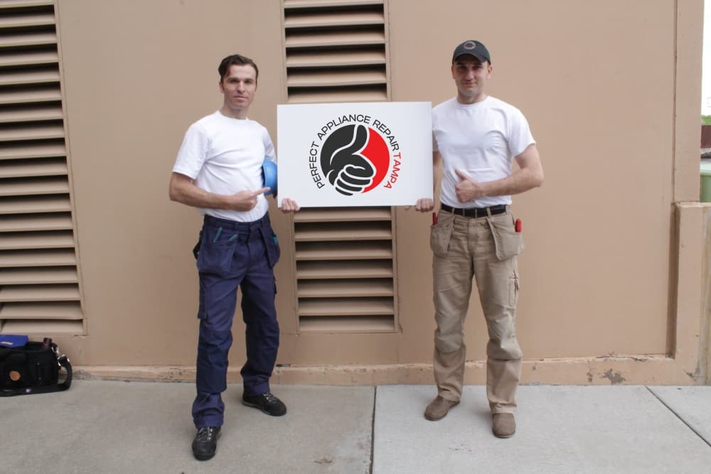 Nick, technician, and Anatoli Didenco, owner, outdoors with the company sign