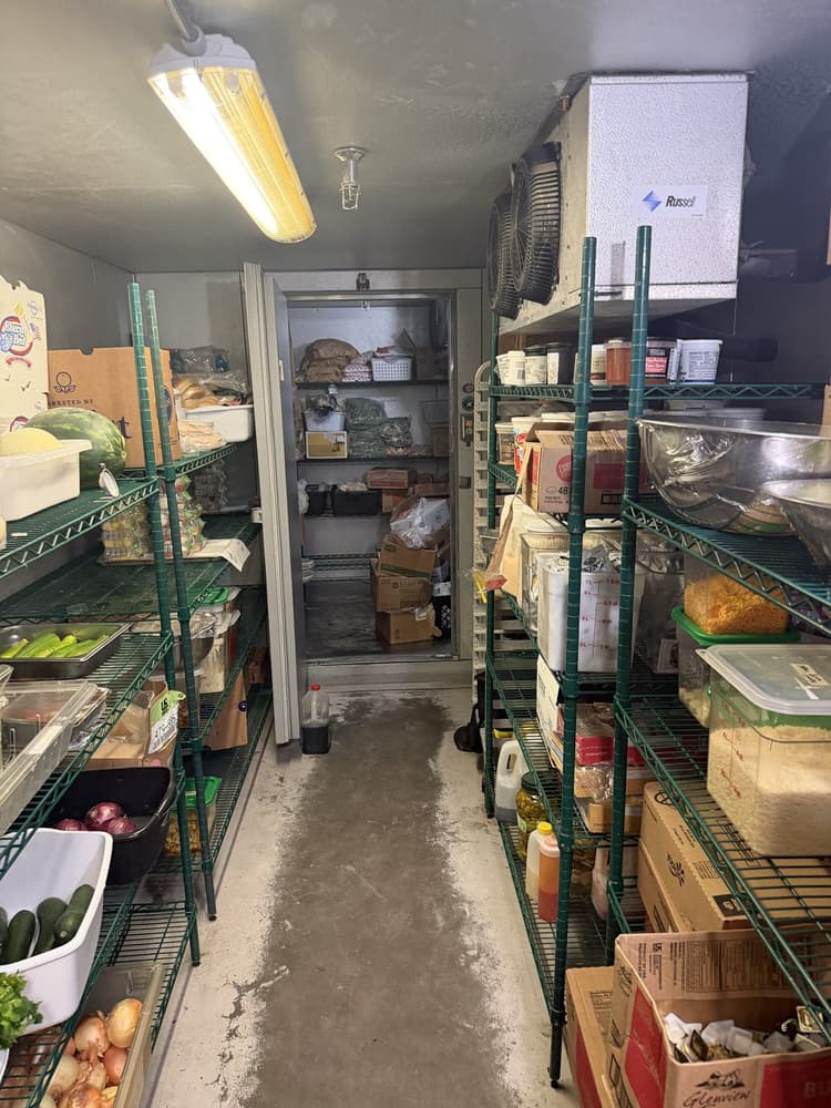 Inside a walk-in cooler in Tampa Bay: Russell evaporator over the shelves, walk-in freezer door behind