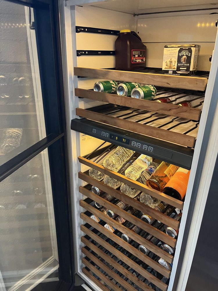 Wine cooler interior with wooden shelves and bottles after a temperature calibration